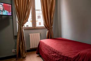 una camera con letto rosso e finestra di Hotel d'Este a Roma