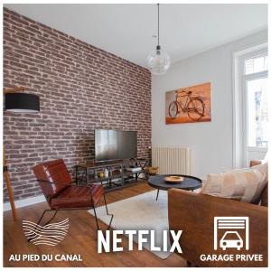 a living room with a brick wall at Le Canal,Hyper centre, Cosy, fibre, parking privée, 1 a 4 pers in Montargis