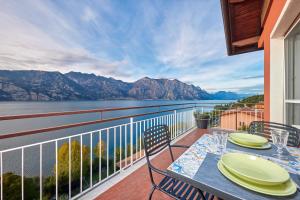 - une table à manger sur un balcon avec vue sur l'eau dans l'établissement Lake View Luca Apartment, à Malcesine