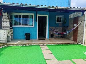 una casa azul con una hamaca delante en Suncoast House, en Cabo Frío