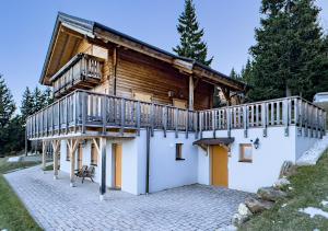 una casa de madera con un balcón en el lateral. en 1A Chalet Koralpenzauber - Wandern, Sauna, Grillen mit Traumblick, en Wolfsberg
