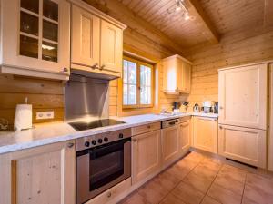 a kitchen with white cabinets and a stove top oven at 1A Chalet Koralpenzauber - Wandern, Sauna, Grillen mit Traumblick in Wolfsberg