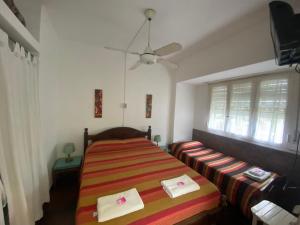 a bedroom with a bed and a ceiling fan at Hospedaje Acacia in Pinamar