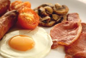 a fried egg on a plate with mushrooms and bacon at Fountains Guest House - Harrogate Stays in Harrogate