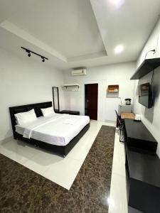 1 dormitorio con 1 cama grande y escritorio en บารอนรีสอร์ทสระแก้ว en Sa Kaeo