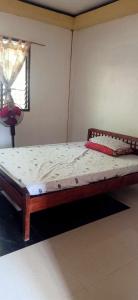 1 dormitorio con 1 cama en una habitación con ventana en HOME of ELLAI en Banga