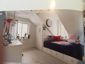 a bedroom with a bed and a clock on the wall at Eksklusivt hus på 250 m2 i naturskønne omgivelser in Hørsholm