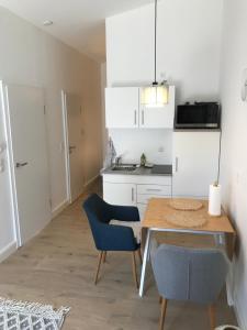 una cucina con tavolo in legno e sedie blu di Schöne 1,5 Zimmer Wohnung mit Aussenterrasse, Nice small 1,5 room flat with an outside terrace a Weichs