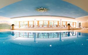 a large swimming pool in a building with a ceiling at Hotel Neuhäusl Superior in Berchtesgaden