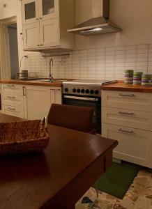 cocina con armarios blancos y mesa de madera en Etna Charming Apartment, en Linguaglossa