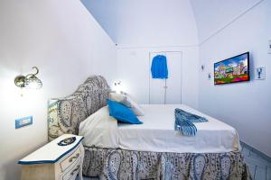 1 dormitorio pequeño con 1 cama y 1 silla en AMORE RENTALS - Maison Don Rafe, en Positano
