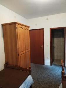 a bedroom with a wooden cabinet and a closet at Prenoćište San Rooms in Livno