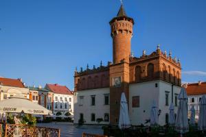 ein Gebäude mit einem Uhrturm darüber in der Unterkunft Euro Aparthotel in Tarnów