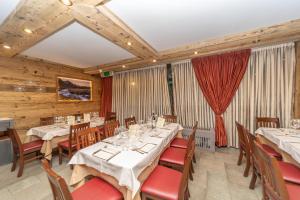 a dining room with tables and chairs and wooden walls at HOTIDAY Chalet Sestriere Vialattea in Sestriere