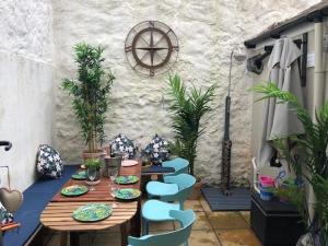 a wooden table and chairs on a patio at Mermaid Cottage Teignmouth by the beach SLEEPS 7 in Teignmouth