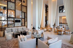 a lobby with couches and chairs and a bar at Hotel Boulevard, Autograph Collection in Dubai