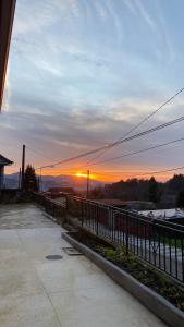 a sunset behind a fence with the sun in the distance at Casa rural completa y con garaje in Vigo