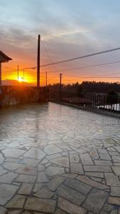 a sunset with the sun setting behind a stone patio at Casa rural completa y con garaje in Vigo