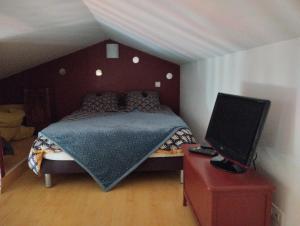 a bedroom with a bed and a laptop on a dresser at L'eden naturiste spas in Challans
