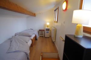 Cette chambre comprend deux lits et une table avec une lampe. dans l'établissement Maison de charme au Mont Valérien avec jardin privatif, à Nanterre