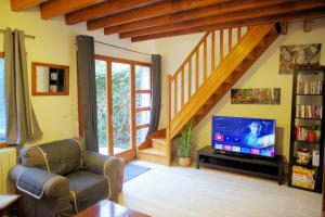 - un salon avec une télévision et un escalier dans l'établissement Maison de charme au Mont Valérien avec jardin privatif, à Nanterre