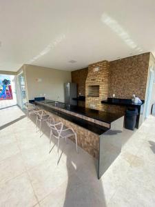 a bar with stools in a room with a brick wall at Apartamento em Ponta de Campina in Cabedelo