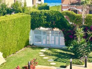 a garden with a gate with a hedge and flowers at Luxury Villa with pool in Hurghada in Hurghada