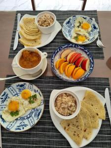a table with plates of breakfast food on it at Empyrean Stay, Maldives in Thulusdhoo