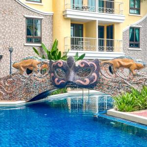 einen Brunnen vor einem Gebäude neben einem Pool in der Unterkunft Espana Resort Jomtien Beach Pattaya in Jomtien Beach