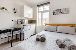 a white bedroom with a bed and a kitchen at Double Room No,4 Edmonton Green, London N9 in London