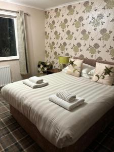 a bedroom with a large bed with towels on it at Highfield in Lissett