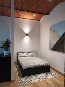 ein Schlafzimmer mit einem Bett in einer weißen Wand in der Unterkunft Apartament Sobieskiego in Nowy Sącz