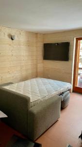 a bedroom with a large bed with a flat screen tv at Lys Apartment in Gressoney-la-Trinité