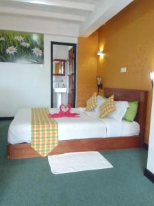 a bedroom with a large bed with a bow on it at Red wood Inn in Nuwara Eliya