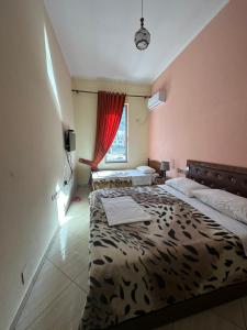 sypialnia z 2 łóżkami i oknem w obiekcie Hotel Zogu w mieście Bulqizë