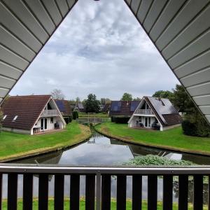 - un balcon avec vue sur les maisons et le canal dans l'établissement Luxe 6-persoons vakantiewoning Gramsbergs Huuske, à Gramsbergen