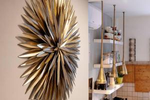 a large feather sculpture on a wall in a kitchen at Cozy house at Vatican/StPeter's dome shade. in Rome