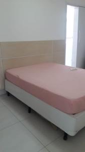 a bed in a room with a pink mattress at Apto Guaruja Astúrias in Guarujá