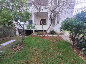 a white house with trees in front of it at Garden house in Kashari