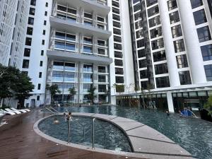 a large building with a swimming pool in front of it at Seaview Designer Concept The shore Kota Kinabalu Sabah by UsHomestay in Kota Kinabalu