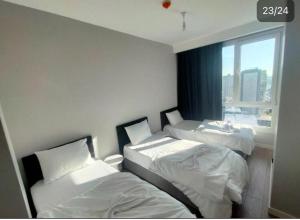 - 2 lits dans une chambre avec fenêtre dans l'établissement Cozy central 2+1 with balcony, à Istanbul