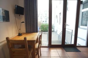 a dining room table with chairs and a sliding glass door at Pension Mädchenkammer in Berlin