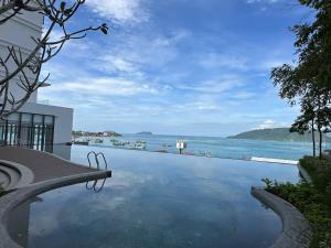 a swimming pool with a view of the water at Seaview Designer Concept The shore Kota Kinabalu Sabah by UsHomestay in Kota Kinabalu