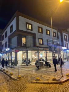 a building with people walking in front of it at night at Hotel Almina Park in Duzce
