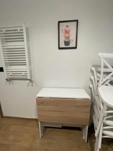 een witte kamer met een houten dressoir en een raam bij Un appartement S+1 agréable et spacieux ( terrasse) in Nabeul