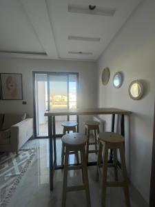 a room with a bar with stools and a window at Un appartement S+1 agréable et spacieux ( terrasse) in Nabeul