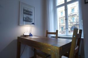 een houten tafel in een kamer met een raam bij Pension Mädchenkammer in Berlijn