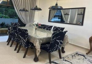 - une salle à manger avec une table, des chaises et un miroir dans l'établissement Homestay Durian Belanda, à Jertih