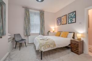 a bedroom with a large bed and a chair at Belfast City Centre - 3 bed, 3 bathroom & parking by StayByNumbers in Belfast