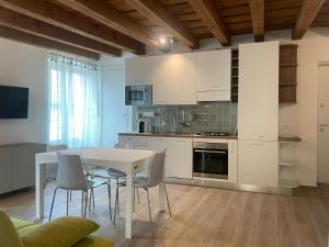 a kitchen with white cabinets and a table and chairs at CAIROLI14 in Brescia